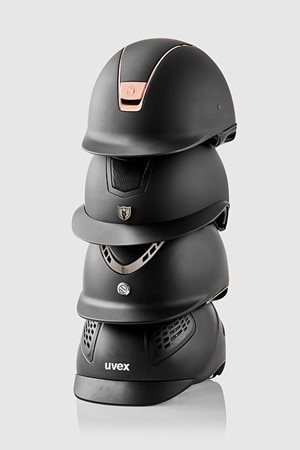 A stack of four equestrian helmets